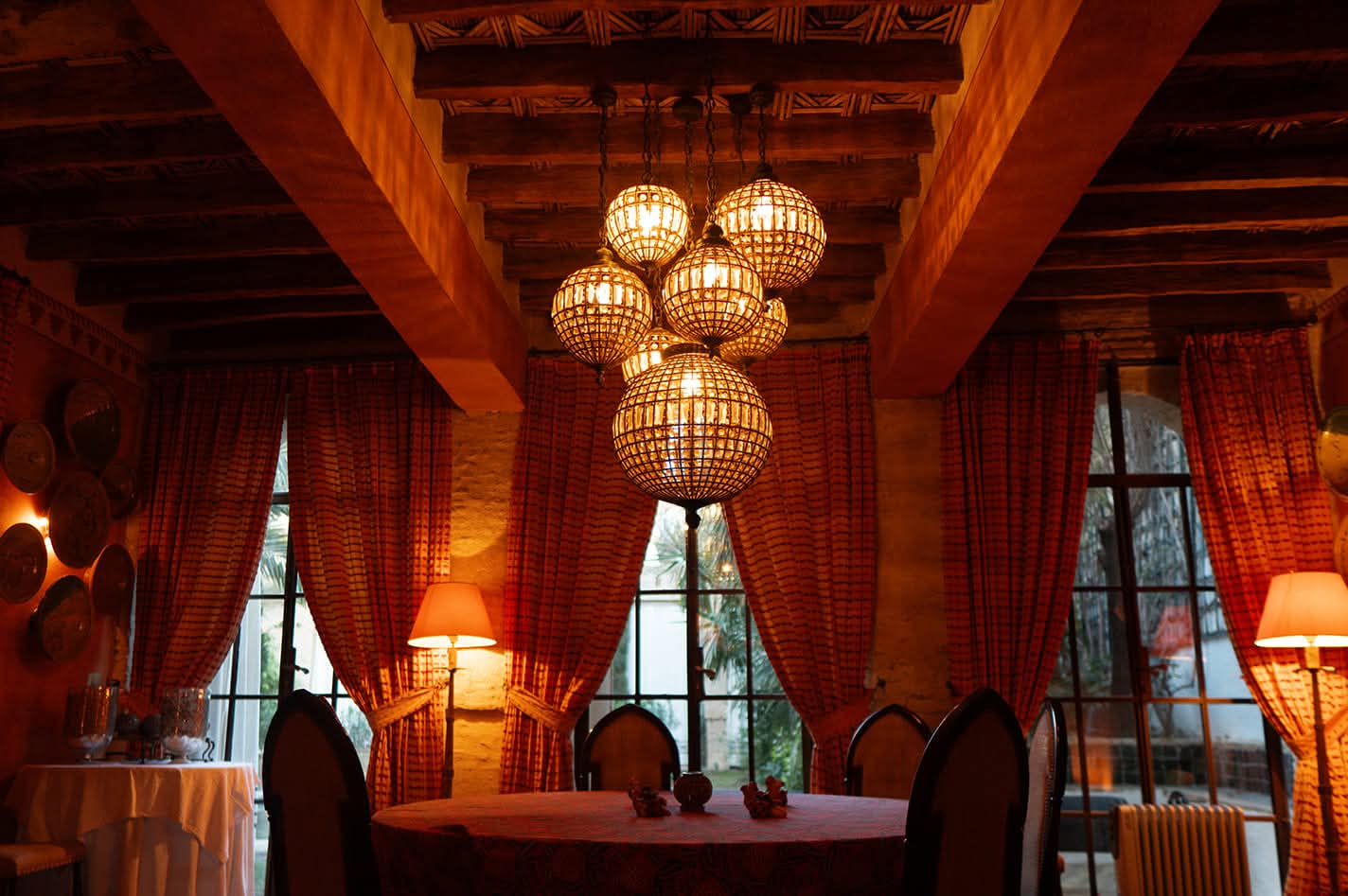 Salle à manger aux rideaux safran et globes lumineux