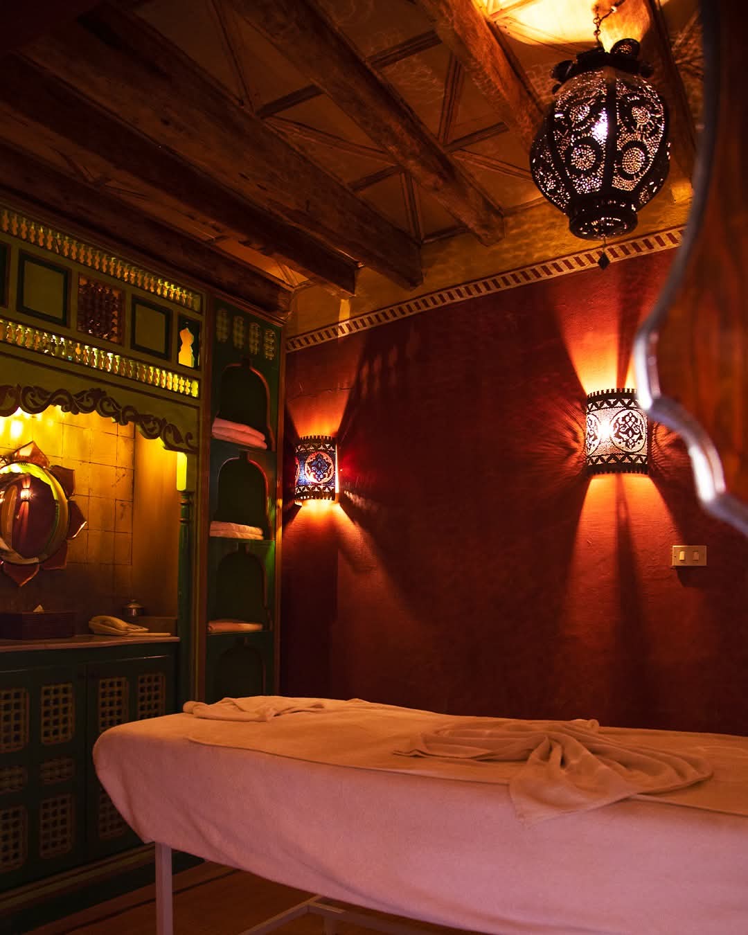 Salle de massage aux appliques ajourées et murs rouges