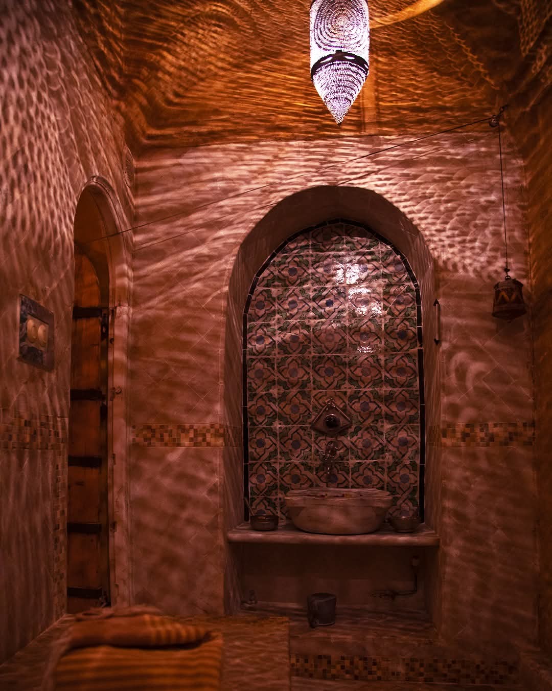 Hammam de marbre à la vasque ancienne sous la lanterne