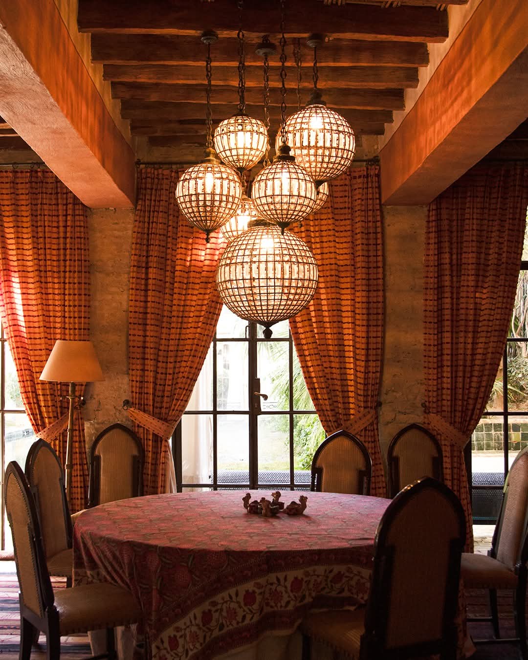 Salle à manger au crépuscule, globes de cristal et rideaux safran