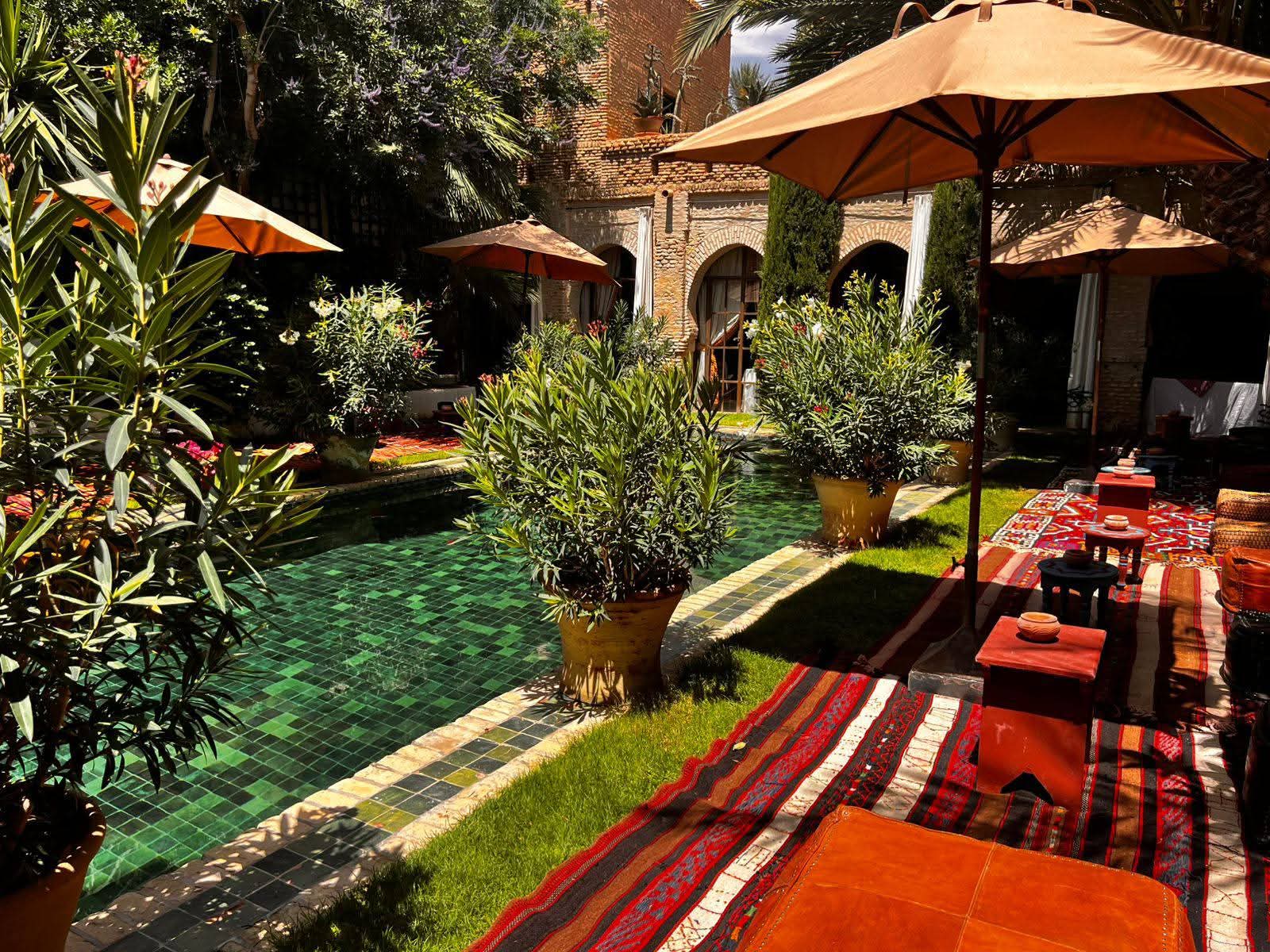 Parasols et kilims au bord du bassin de zellige