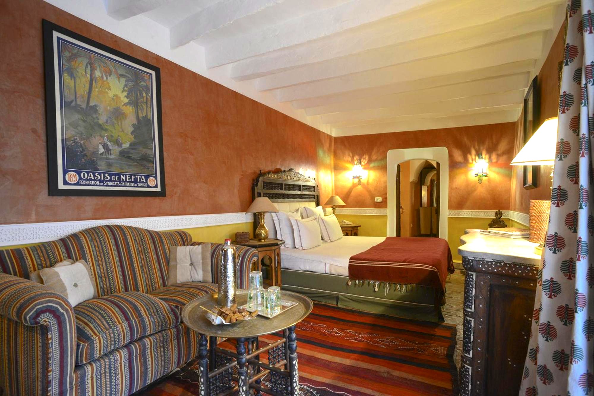 Suite Palmier — tadelakt terracotta et affiche de l'oasis de Nefta